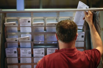 Un operario municipal coloca las papeletas en una cabina en el colegio electoral situado en el edificio Novíssim del Ayuntamiento de Barcelona donde se ultiman los preparativos para las votaciones de las elecciones catalanas que se celebrarán este próximo domingo día 12 de mayo. EFE/Alberto Estévez