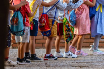 Niños y niás a la puerta de un colegio.