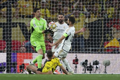 El guardameta belga del Real Madrid, Thibaut Courtois (i), captura el balón ante sus compañeros y el delantero del Borussia Dortmund, Niclas Fulkrug, durante el encuentro correspondiente a la final de la Liga de Campeones que Real Madrid y Borussia Dortmund disputaron en el estadio de Wembley, en Londres. EFE / Kiko Huesca.