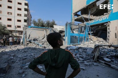 Nuseirat Camp (Gaza).- Ciudadanos palestinos inspeccionan una escuela de Naciones Unidas bombardeada por Israel este domingo. EFE/EPA/MOHAMMED SABER