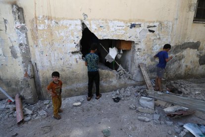 Niños palestinos observan los daños causados en un edificio tras una incursión israelí en el campo de refugiados de Al Farea, cerca de la ciudad de Tubas, en Cisjordania, en una imagen de archivo. EFE/EPA/ALAA BADARNEH