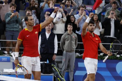 Los tenistas españoles Rafael Nadal (i) y Carlos Alcaraz celebran la victoria en el partido de dobles frente a los argentinos Máximo González y Andrés Molteni, correspondiente a la primera ronda de dobles masculino de tenis de los Juegos Olímpicos de París 2024 en la pista Phillipe Chatrier de París. EFE/ Juanjo Martín