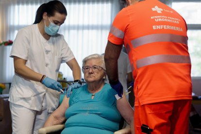 Imagen de archivo (3/10/2023) de una anciana recibiendo la vacuna en una residencia de la tercera edad de Ávila. EFE/Raúl Sanchidrián