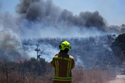 Bomberos desplegados para apagar un incendio que se produjo debido a proyectiles disparados desde el sur del Líbano, en Ayelet HaShahar, Alta Galilea, norte de Israel, el 17 de agosto de 2024. 
                      EFE/EPA/ATEF SAFADI