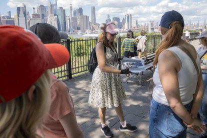 La escritora y una de las fundadoras del tour de gatos en Brooklyn, Peggy Gavan (c), muestra una imagen a un grupo de mujeres este lunes en Nueva York (EE.UU.). EFE/ Ángel Colmenares