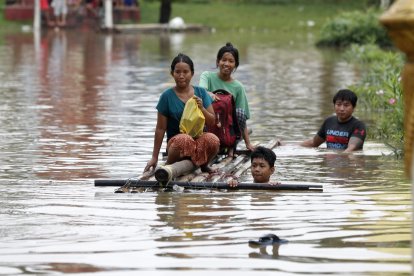 Varias personas se mueven el sábado en una balsa por las calles de la localidad de Taungoo en Birmania (Myanmar), afectada por las inundaciones. EFE/ Nyein Chan Naing