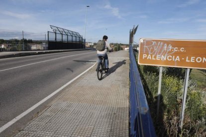 Un ciclista atraviesa el paso superior de Trobajo del Cerecedo sobre las vías. RAMIRO