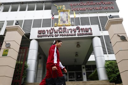 Familiares de los fallecidos por el incendio en un autobús escolar en Bangkok llegan al Instituto Forense para identificar a las víctimas. 
                      EFE/EPA/NARONG SANGNAK