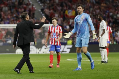 El portero del Real Madrid Thibaut Courtois (d) conversa con el entrenador del Atlético, Diego Simeone (i), durante el partido de la LaLiga EA Sports que Atlético de Madrid y Real Madrid en el estadio Civitas Metropolitano. EFE/Ballesteros