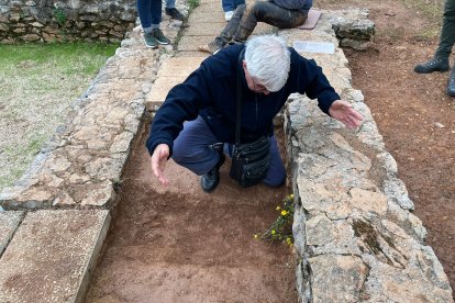 José Antonio Blanco, nieto de Ceferino López, deja un ramo de flores en la fosa exhumada en la domus de Lago de Preiras donde pudo estar enterrado su abuelo durante nueve décadas.