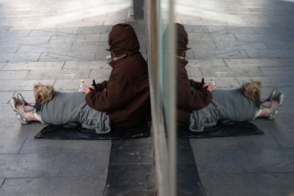 Una persona sin hogar pide en una céntrica calle de Madrid.-EFE/Mariscal