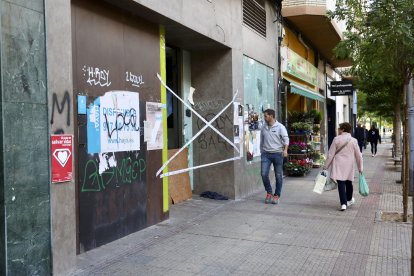 Peatones pasan este viernes por delante del local donde dos personas que dormían en su interior han fallecido esta madrugada a causa de un incendio, según los datos iniciales facilitados a EFE por fuentes cercanas a la investigación. EFE/ Raquel Manzanares