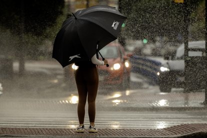 Una mujer se resguarda de la lluvia bajo un paraguas este martes en Málaga.EFE/Jorge Zapata.