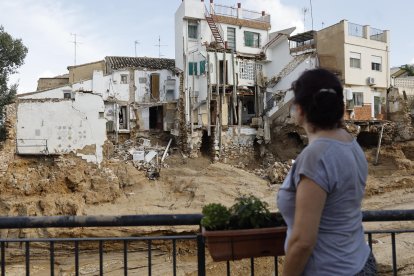 Una mujer observa varias casas dañadas en Chiva tras la dana este jueves. EFE/Kai Försterling