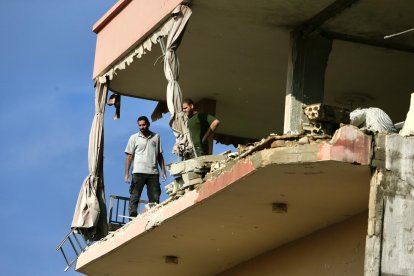 Dos hombres miran hacia un edificio destruido durante un ataque aéreo israelí en la ciudad sureña libanesa de Ghazieh, 03 de noviembre de 2024. 
                       EFE/EPA/STR