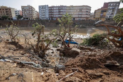 Restos de vehículos arrastrados por la corriente en el barranco del Poyo en Paiporta, Valencia, este lunes.