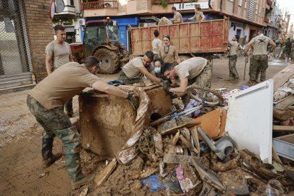 Un grupo de militares ayuda en labores de limpieza en el municipio valenciano de Sedaví este martes, tras el paso de la Dana. EFE/ Biel Alino