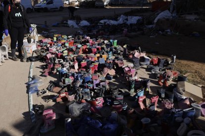 Botas de agua donadas permanecen apiladas en Paiporta (Valencia) este lunes. . EFE/ Kai Forsterling