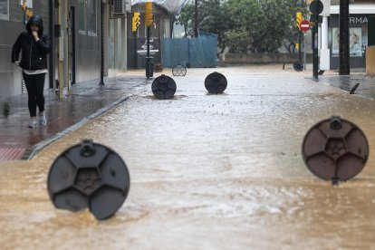 Alcantarillas abiertas en una calle de la barriada de Campanillas en Málaga, en la que el paso de la dana ha obligado a nuevos desalojos preventivos. EFE/Daniel Pérez