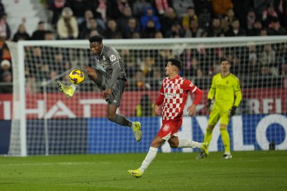 El centrocampista del Real Madrid Aurélien Tchouaméni (i) disputa un balón ante el delantero del Girona Bojan Miovski, durante el partido de la jornada 19 de LaLiga que Girona FC y Real Madrid disputan este sábado en el estadio Montilivi, en Girona. EFE/Alejandro García