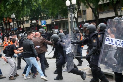 Imagen de archivo del 01/10/2017 de varios agentes de la Policía Nacional intentan retirar a los concentrados en el instituto IES Tarragona. EFE/Jaume Sellart