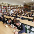 Varios niños ojean libros en una de las aulas del colegio La Asunción, que acoge a cerca de 700 alumnos que cursan desde Infantil hasta segundo de Bachillerato en el centro educativo leonés.