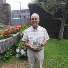 Primitivo Martínez posa con el libro en la casa familiar de Faro (Peranzanes).