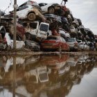 Coches arrastrados por el agua tras el paso de la dana, almacenados en un descampado en Paiporta este viernes. EFE/ Biel Aliño
