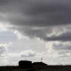 Una persona camina bajo un cielo cubierto de nubes en León.