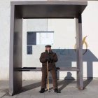 Un hombre espera en una parada de autobús.