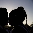 Una pareja se besa durante una ceremonia.