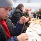 Un niño aprende el minucioso arte del montaje de la mosca artificial.