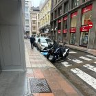 El agente de la Policía y la grúa, este jueves a primera hora, en la reserva de aparcamiento para concejales, en la calle Héroes Leoneses.