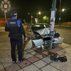 Un agente en la Policía Local junto al coche siniestrado.