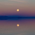 La luna llena se refleja en el salar de Uyuni, la salina más grande del mundo, en Bolivia.