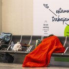 Una persona sin techo duerme en un aeropuerto.