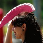 Una mujer combate el calor con un abanico.