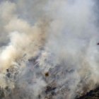 Un helicóptero trabaja en la tareas de extinción del incendio forestal de alta intensidad que se inició el lunes en Paüls (Tarragona) y que afecta ya a un total de 3.137 hectáreas, en su mayoría forestales y de ellas más de mil dentro del Parque Natural de Els Ports.EFE/ Quique García.