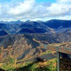 La alcaldesa de Páramo del Sil, Alicia García, señala la zona calcinada desde la zona del Miro y lo verde que se salvó de la braña de Anllares. Detrás está Fornela.
