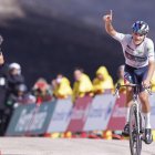 Pellizzari, de blanco como mejor joven de la Vuelta, celebra su triunfo en el Morredero con un fondo negro del paisaje azotado por unos incendios que aún se lloran.