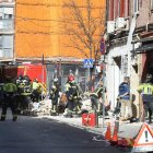 Equipos de emergencias trabajan en la zona donde se ha producido la explosión, que ha tenido lugar en el bar-restaurante Mis tesoros, ubicado en la calle Manuel Maroto de Puente de Vallecas.