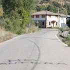 La carretera de entrada a Carrocera con una pintada en contra de volver a abrir la cantera.