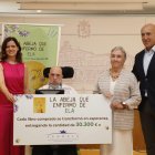 Entrega del cheque recaudado por la venta del libro.