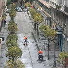 Operarios de la limpieza baldean agua en la calle Juan Lorenzo Segura esta mañana