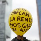 Una persona sostiene un globo durante una marcha contra la gentifricación.