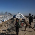 Los niños gazatíes observan el humo tras un ataque israelí.