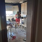 Uno de los bomberos, en la cocina afectada por el fuego.