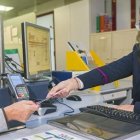 Una operadora atiende a una viajera en una estación.