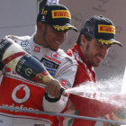 Lewis Hamilton y Fernando Alonso celebran su primer y tercer puesto, respectivamente, logrados en el circuito de Monza.