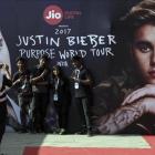 Varios jovenes indios se toman una fotografia con un cartel que publicita la gira mundial del cantante canadiense Justin Bieber antes de su concierto en el estadio Dnyandeo Yashwantrao Patil  en Bombay (India).